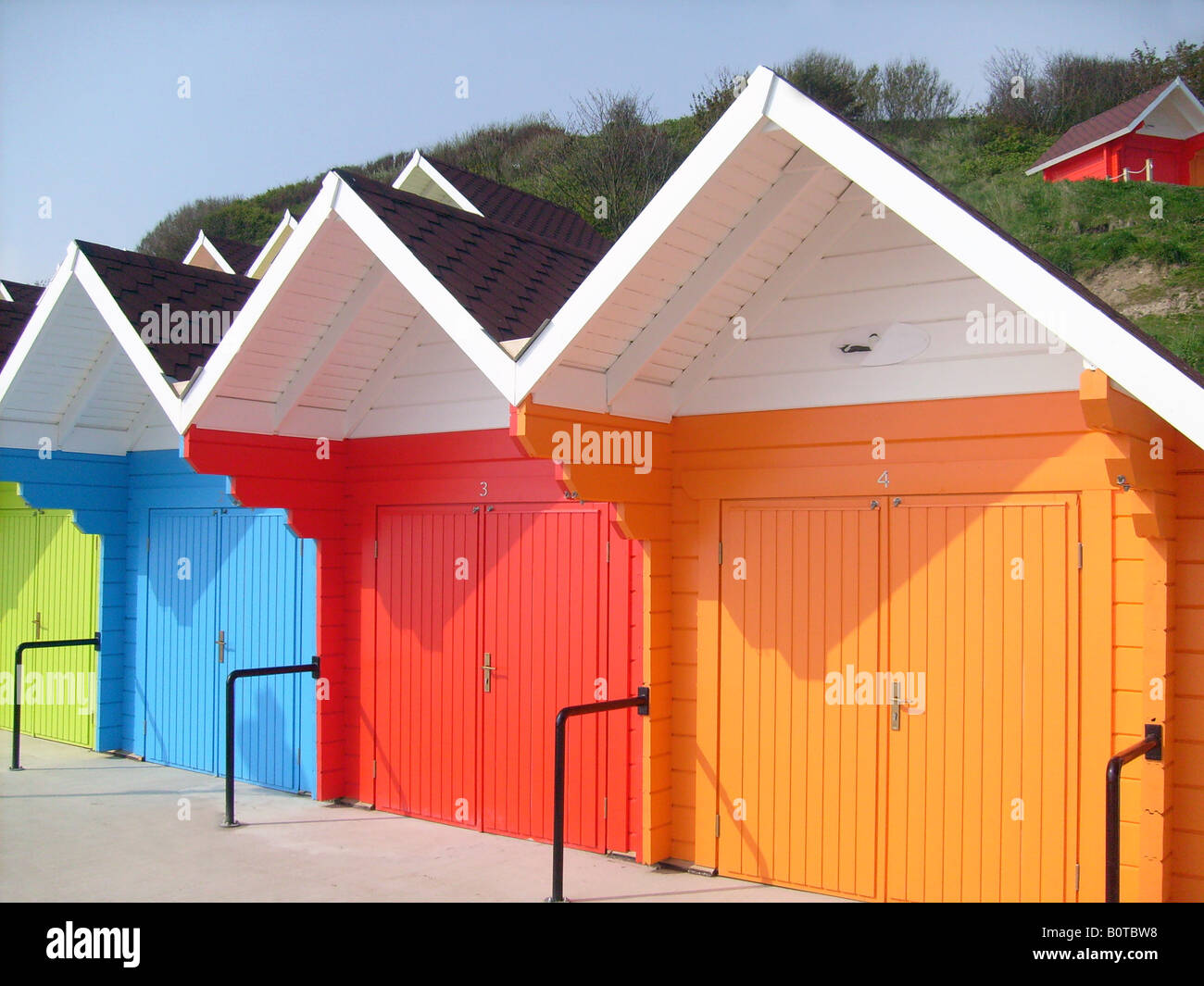 Seaside beach chalets aux couleurs lumineuses, Scarborugh North Bay, Angleterre. Banque D'Images