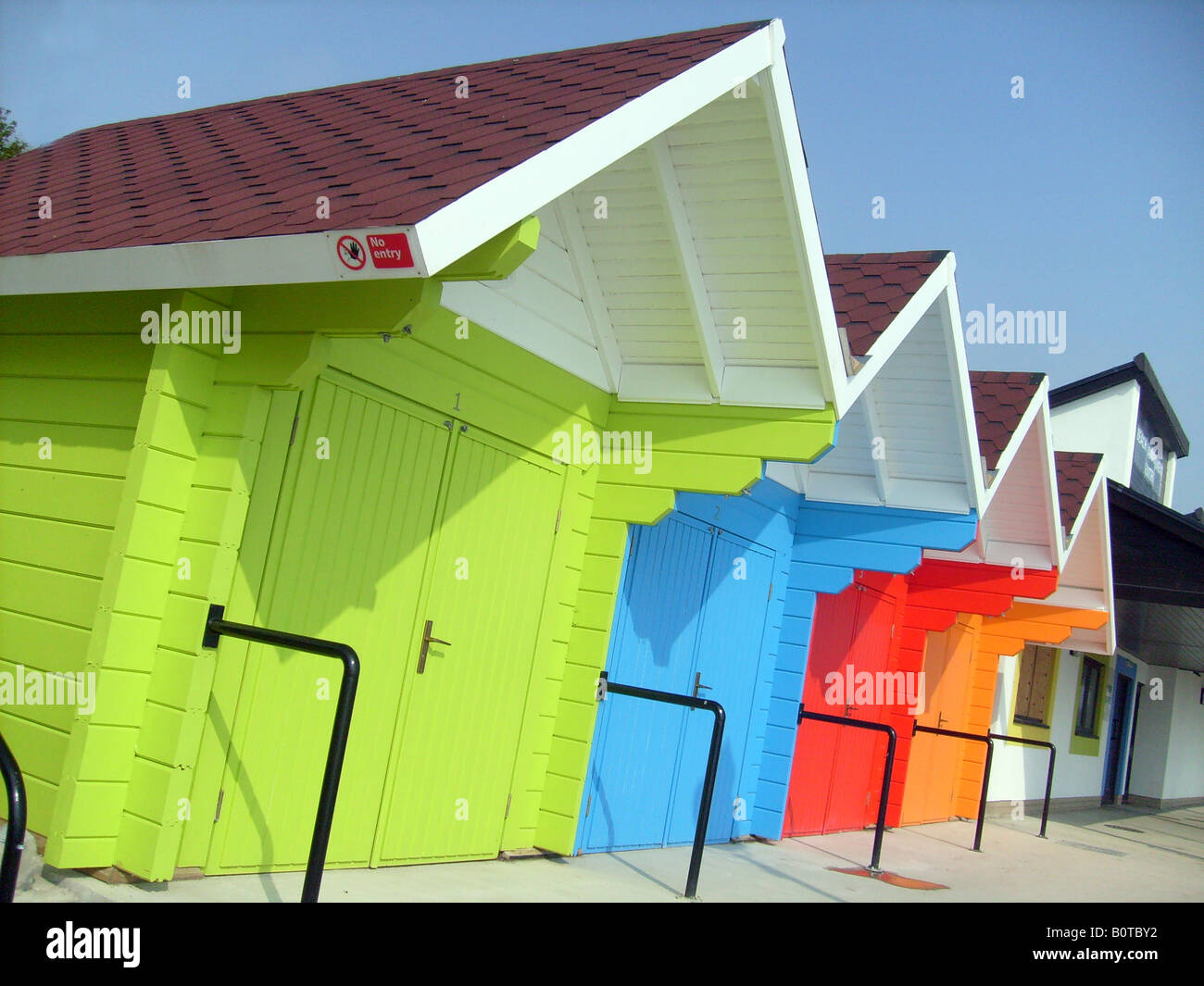 Seaside beach chalets aux couleurs lumineuses, Scarborugh North Bay, Angleterre. Banque D'Images