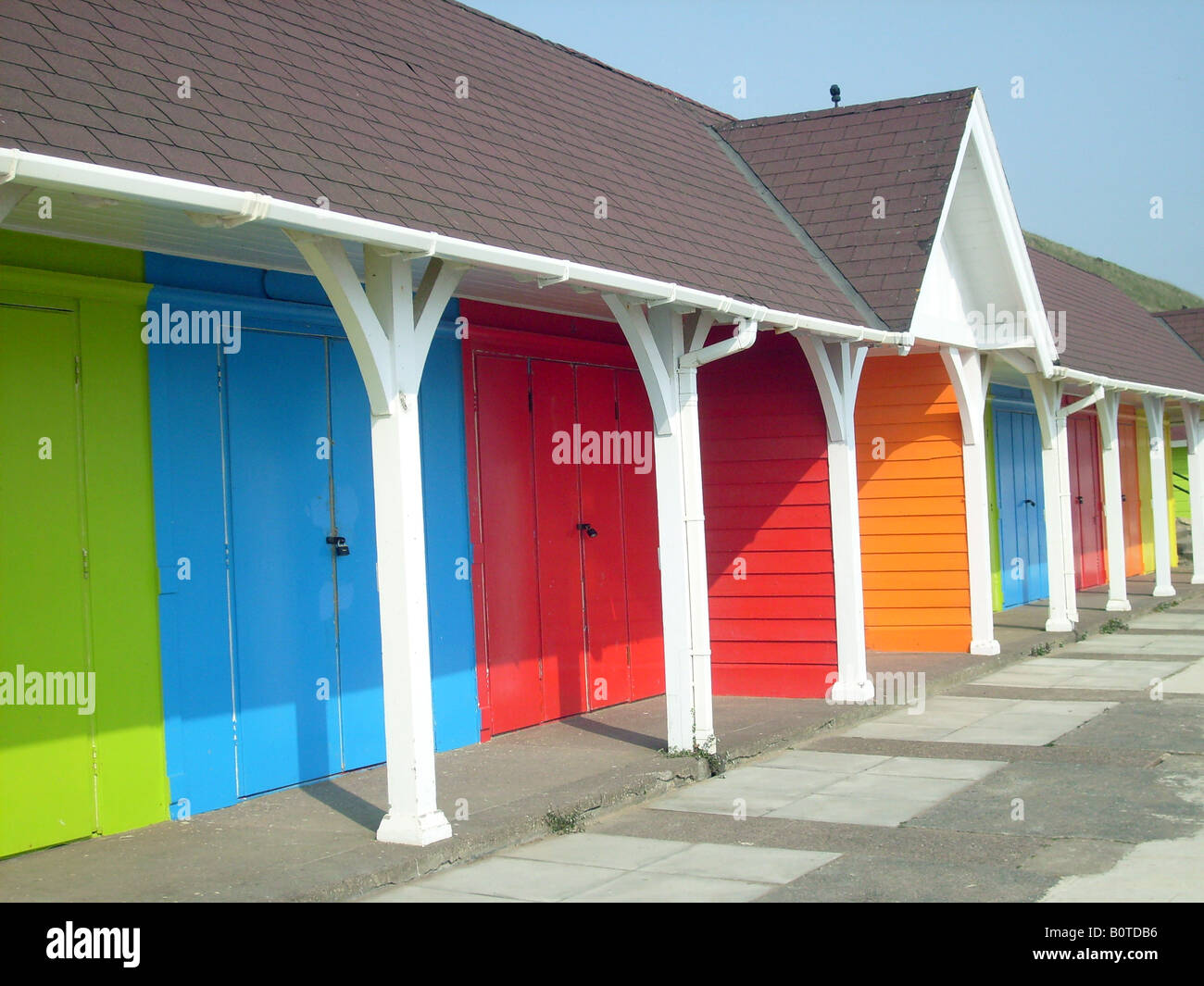 Seaside beach chalets aux couleurs lumineuses, Scarborugh North Bay, Angleterre. Banque D'Images