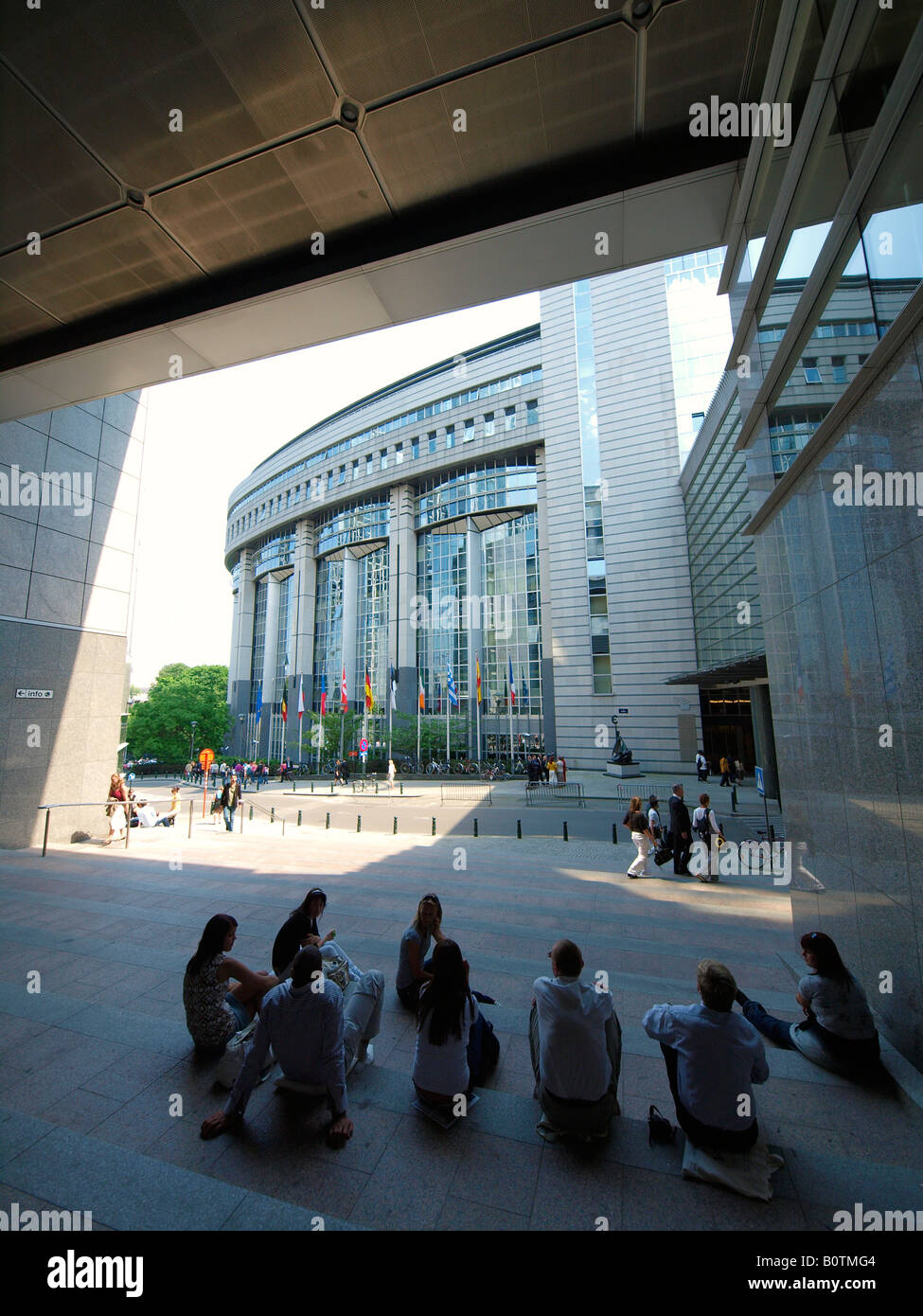 Groupe de gens assis sur les marches en face de l'Union européenne L'UNION EUROPÉENNE Parlement européen à Bruxelles Belgique Banque D'Images