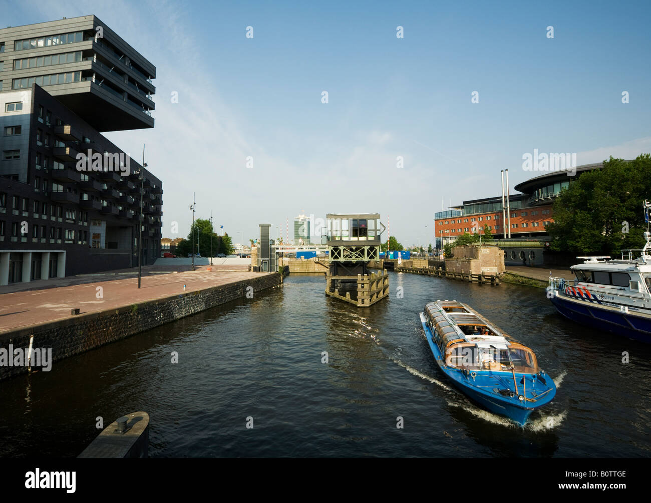 Nouveau bâtiment à Amsterdam Noord Bateau de tourisme dans la Westerdok patrouilleur de la police néerlandaise Banque D'Images