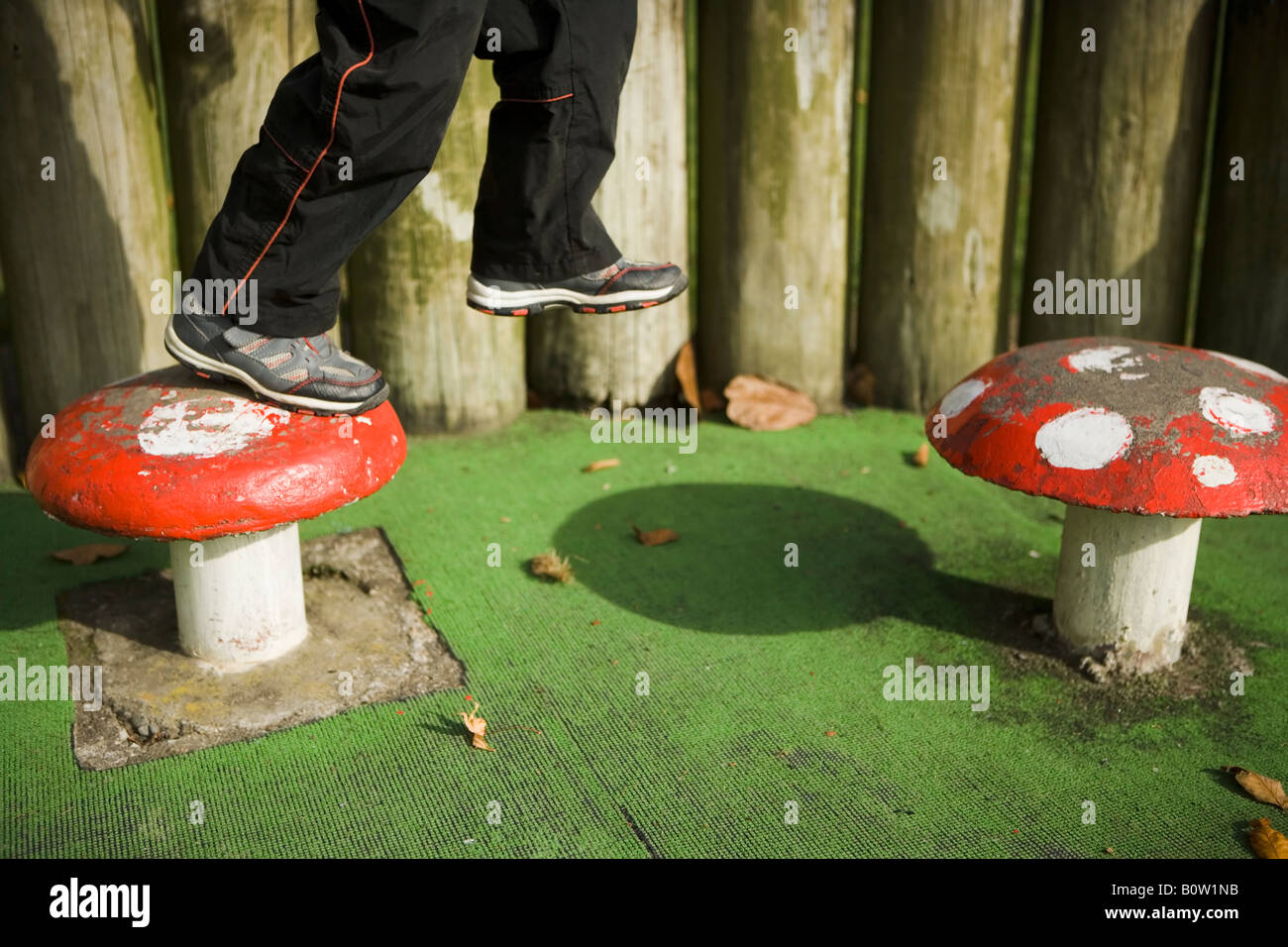 Garçon âgé de 6 étapes sur le béton toadstools dans un parc public Victoria Esplanade Palmerston North Nouvelle Zélande Banque D'Images