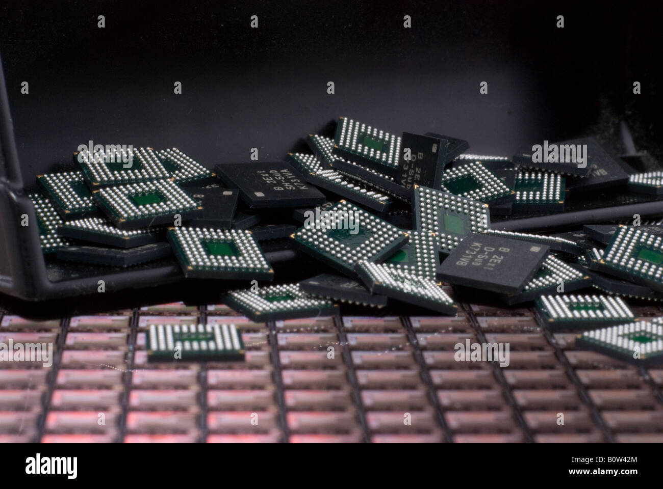 Puces électroniques dans le godet avant d'un creuseur et éparpillés sur une plaquette de silicium Banque D'Images