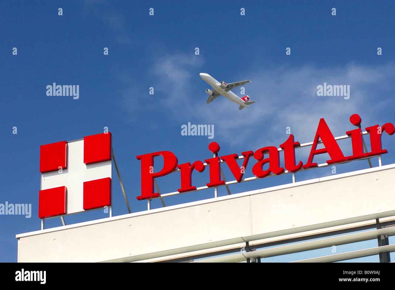 Avion volant au-dessus du siège de la compagnie aérienne PrivatAir, Genève, Suisse, Europe Banque D'Images