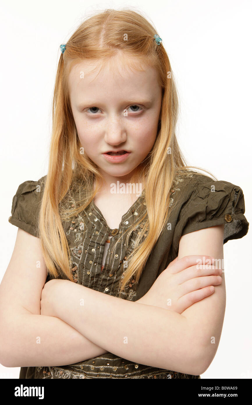 8-year-old girl, regard de colère, les bras croisés Banque D'Images