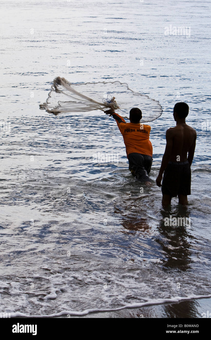 La mer pêcheur debout dans son casting net, île de Lombok, Indonésie, Îles de la sonde Lesser Banque D'Images