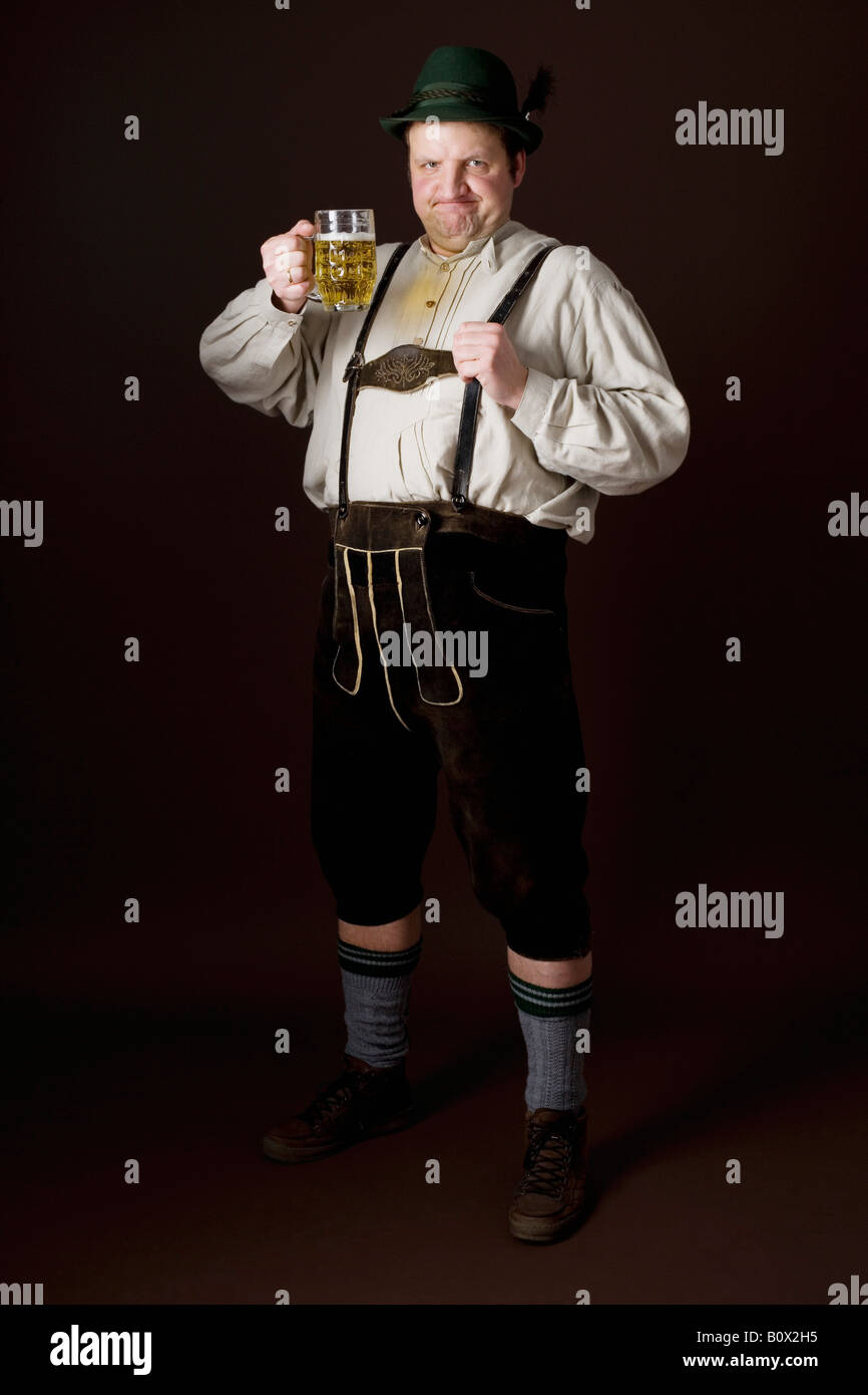 Les stéréotypes l'Allemand man in Bavarian costume raising a beer dans toast Banque D'Images