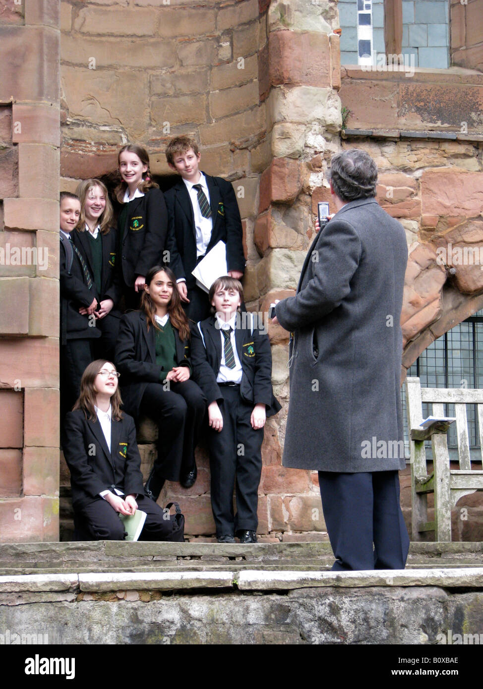 Enseignant de prendre une photo d'un groupe d'élèves dans les ruines de la cathédrale de Coventry, Royaume-Uni, Angleterre, Coventry Banque D'Images