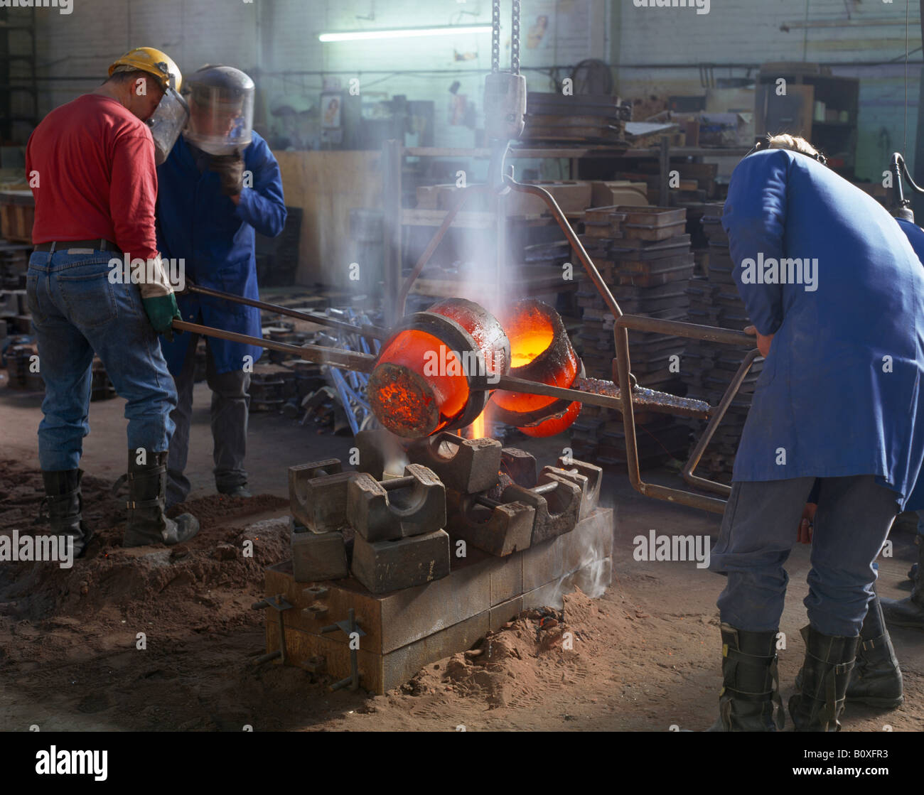 Verser le métal chaud fondeurs dans le moule, Norfolk, Angleterre Banque D'Images