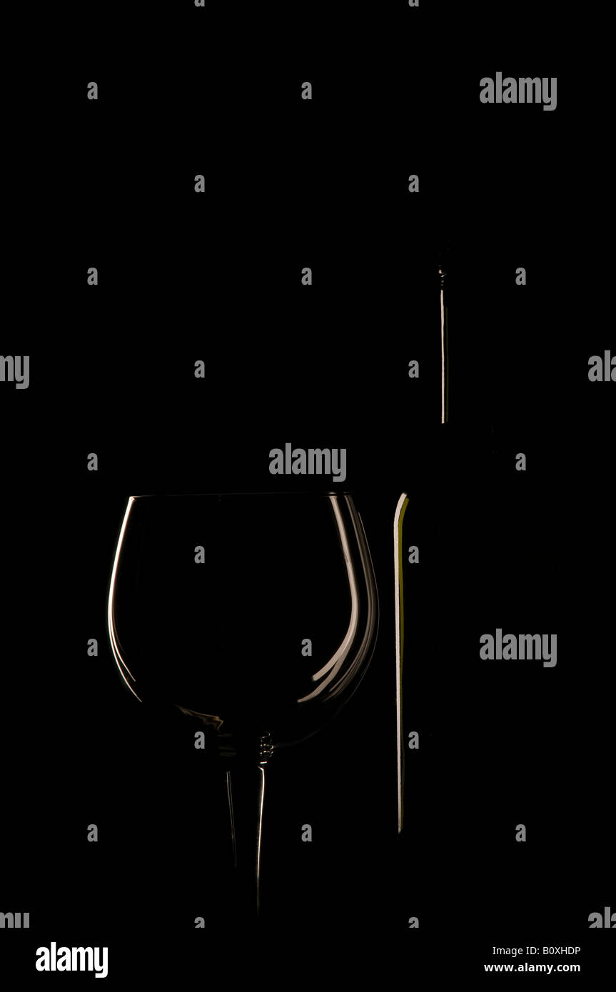 Un verre et une bouteille avec rétroéclairage Banque D'Images