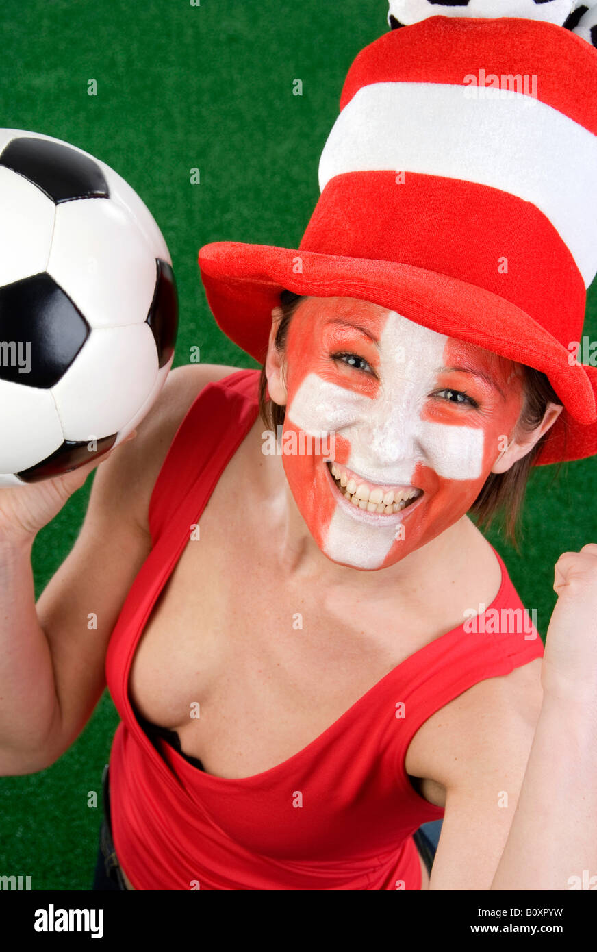 Cute woman in a Red top comme ventilateur Suisse, encourageant avec chapeau et le football Banque D'Images