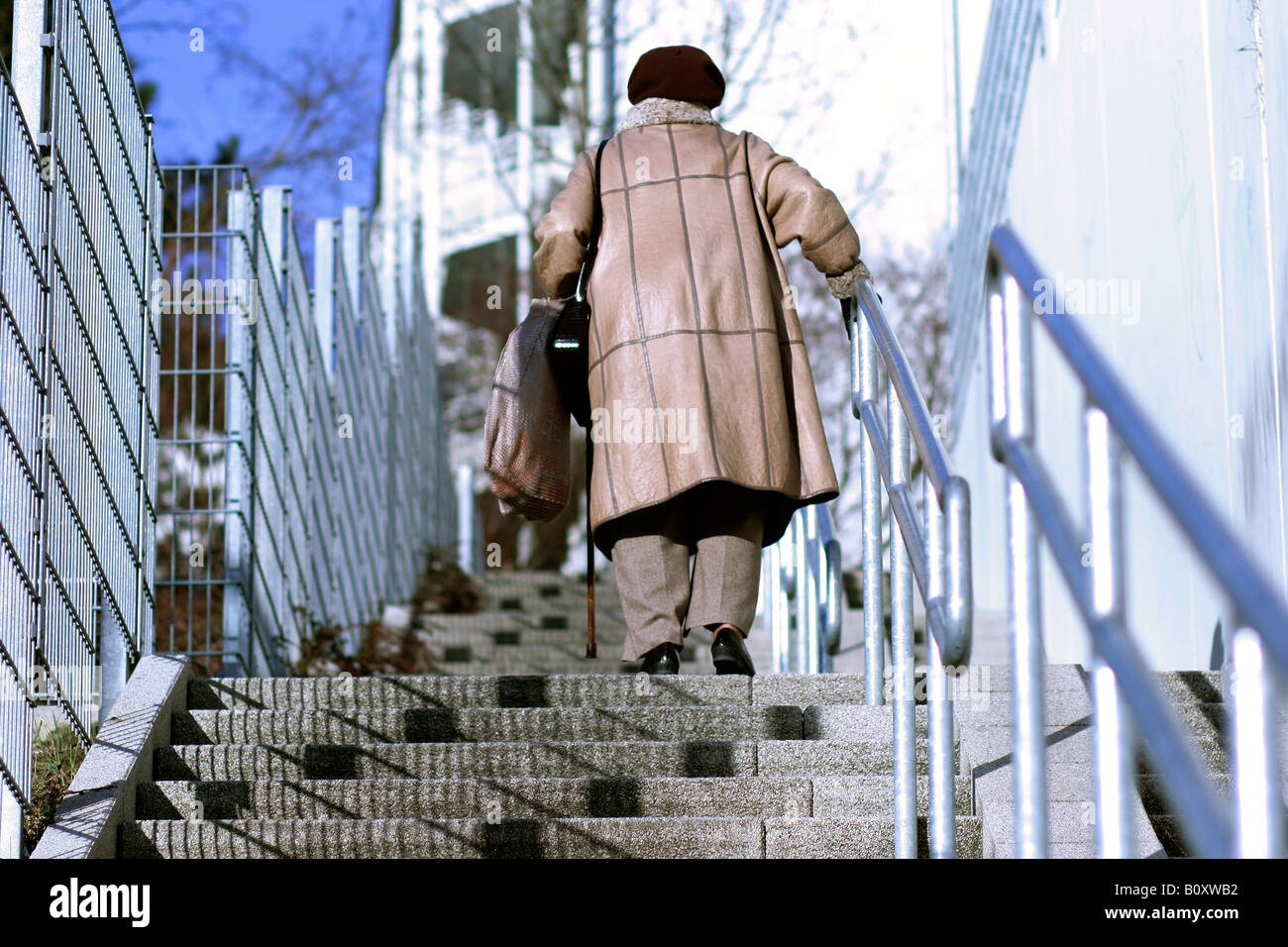 Vieille Femme aller vers le haut de l'escalier Banque D'Images
