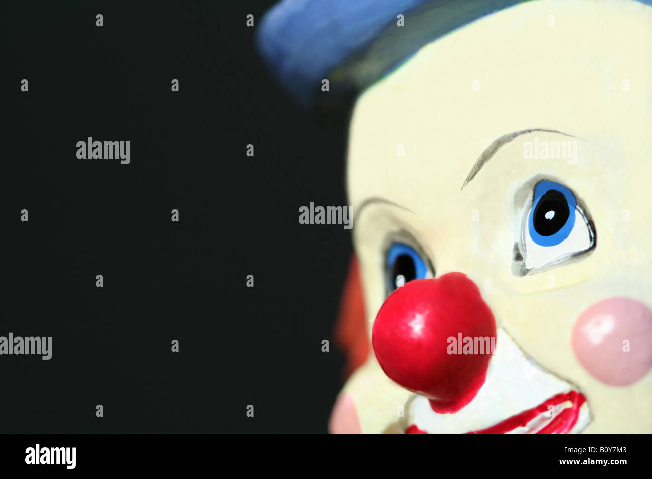 Un jouet le visage de clown sur un fond sombre Banque D'Images