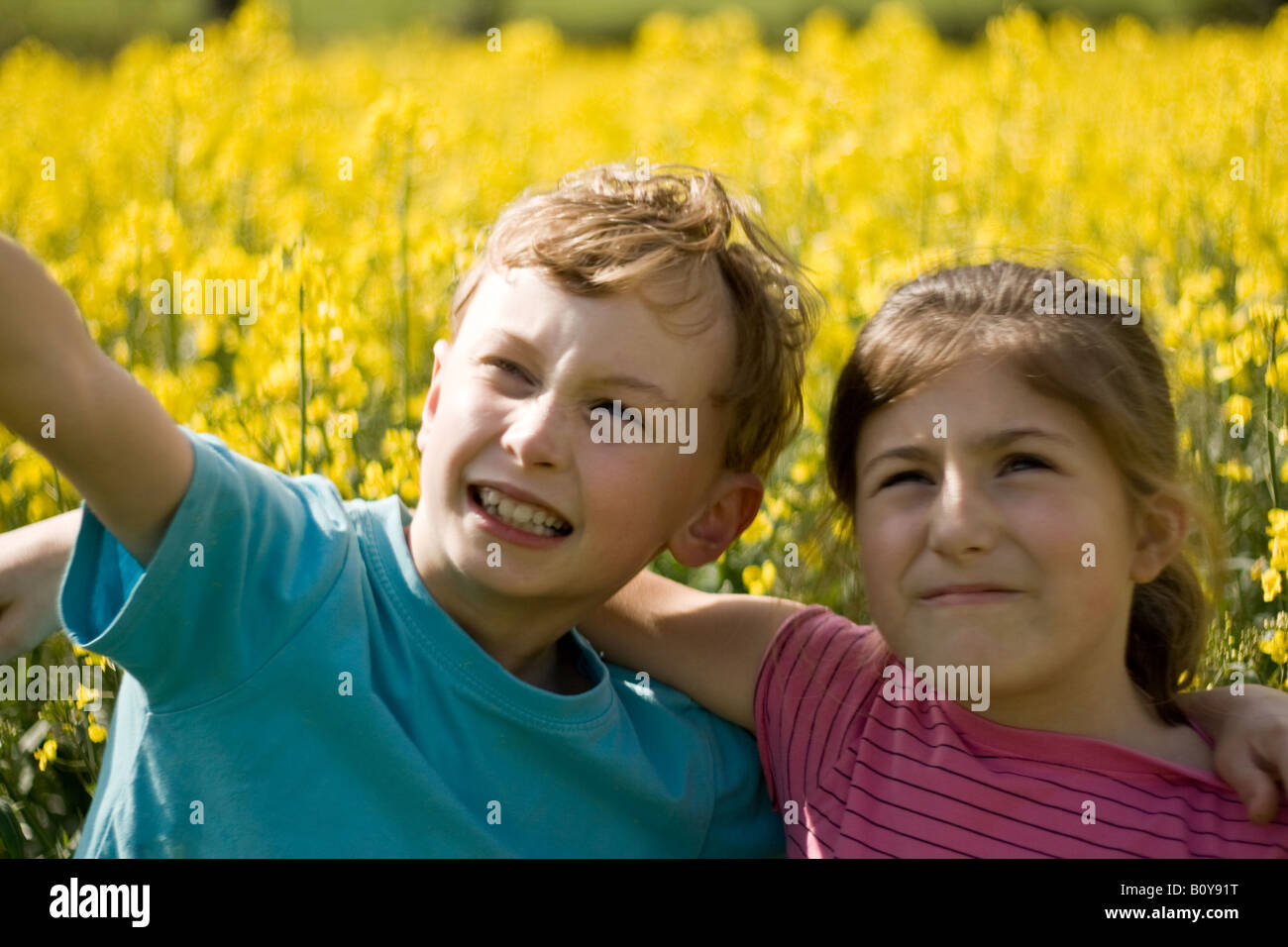 Jeune garçon et fille gambader dans un champ d'été Banque D'Images