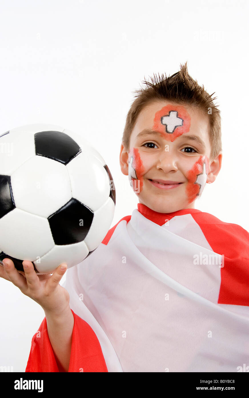Garçon, rouged que Swiss fan de foot, avec le football dans sa main et d'un drapeau Banque D'Images