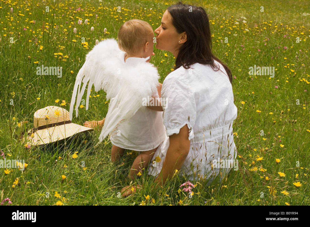 Mother with baby (2-3) dans le pré, les ailes d'ange, vue arrière Banque D'Images