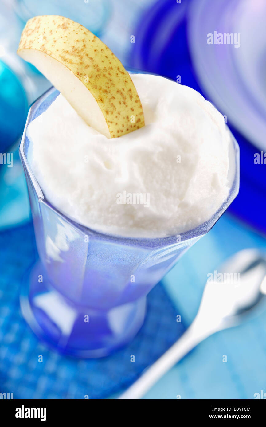 Sorbet au citron glacé servi en verre bleu avec tranche de poire sur table set en bleu, de l'alimentation Banque D'Images