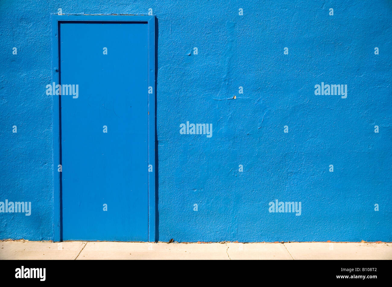 Mur en stuc bleu avec une porte sans manche Banque D'Images