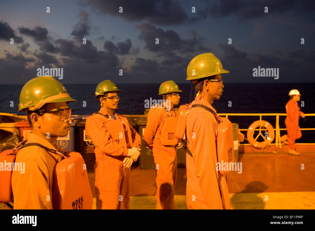 Travailleurs qui attendent sur le pont d'un mazout flottant de production, de stockage et de déchargement FPSO Indonésie 2005 Banque D'Images