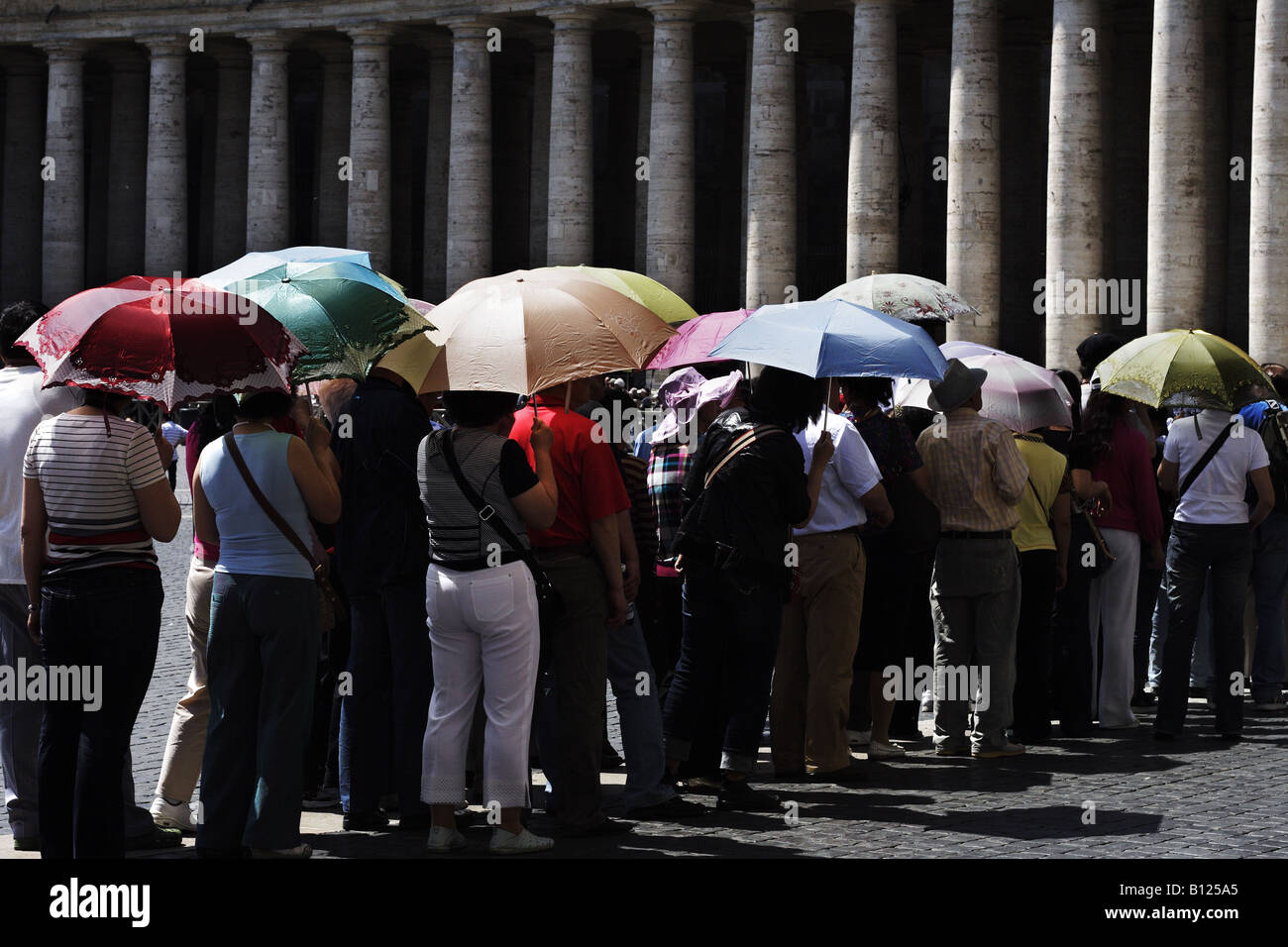 Les touristes avec un parapluie faisant la queue pour entrer dans le Concile Vatican II sur la place Saint-Pierre. Banque D'Images