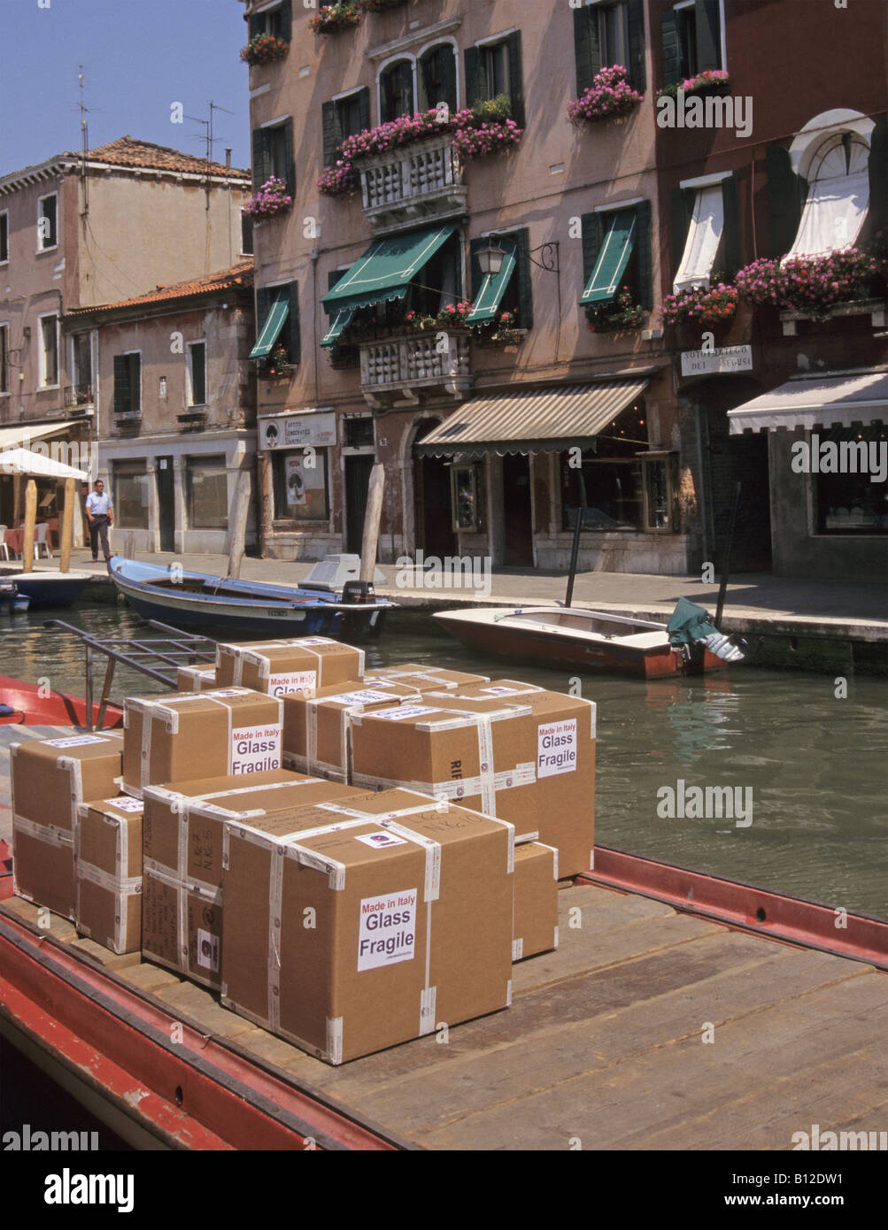 Boîtes de carton contenant des produits en verre sur le bateau amarré au Rio dei Vetrai Canal de l'île de Murano Venise Italie Banque D'Images