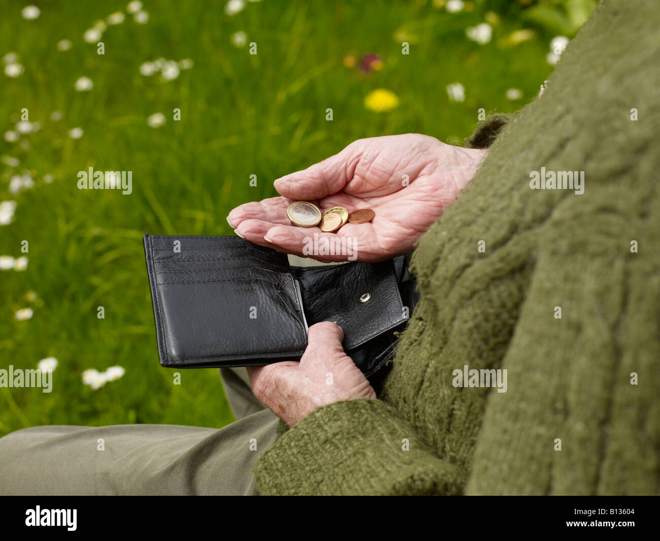 Vieux routiers d'un senior comptant moins d'argent dans un sac à main Banque D'Images