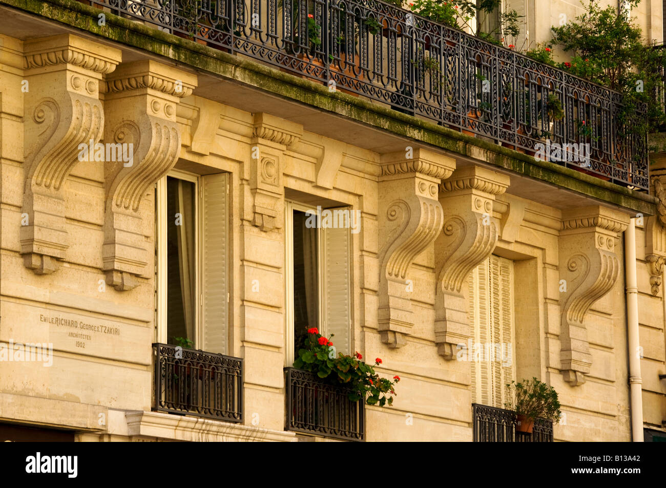 Façade d'un immeuble à Paris avec un balcon et les jardinières de fleurs au printemps. Banque D'Images