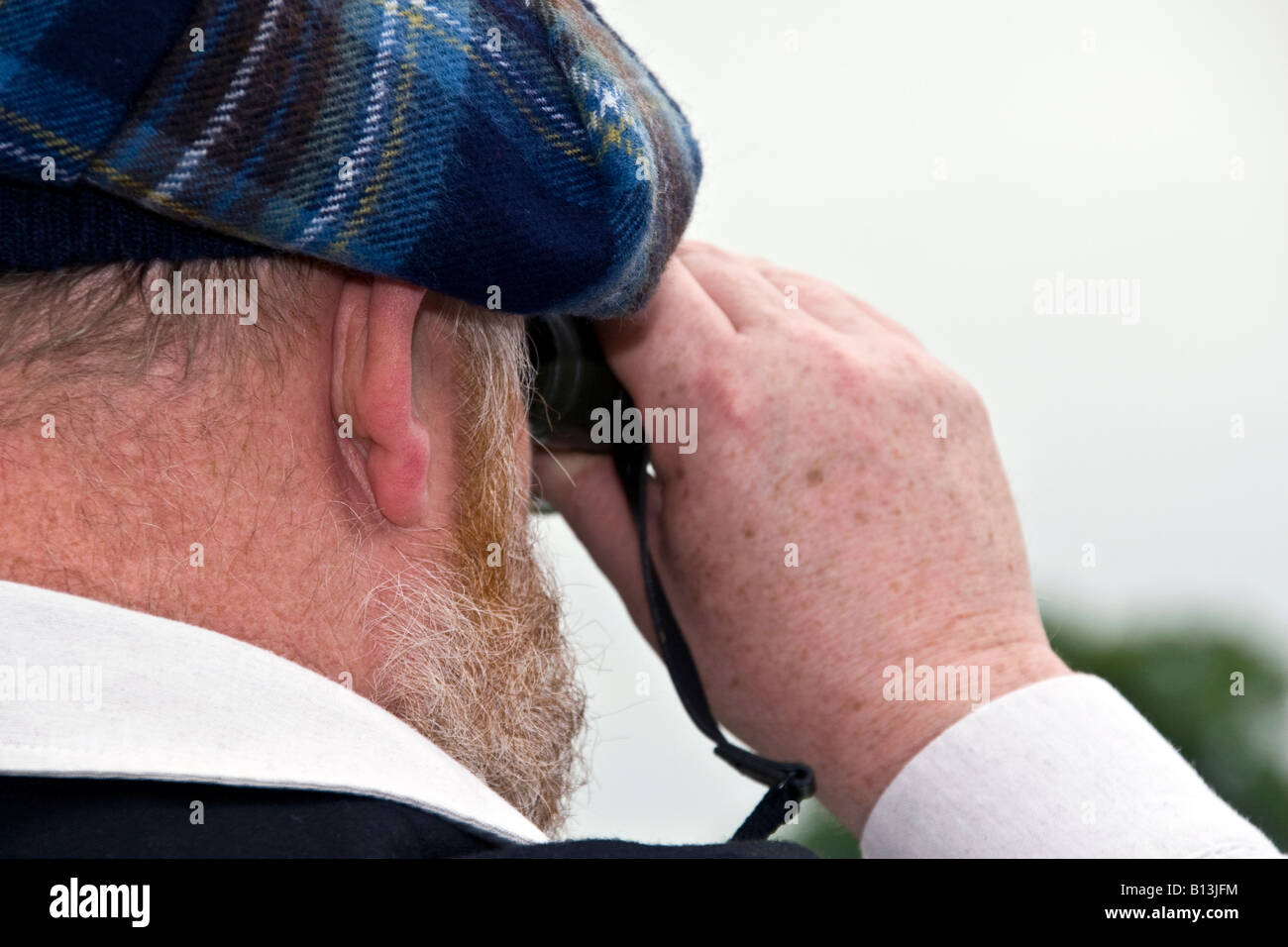 Libre d'un homme regardant à travers des jumelles à l'hippodrome de Perth dans le Perthshire, UK Banque D'Images