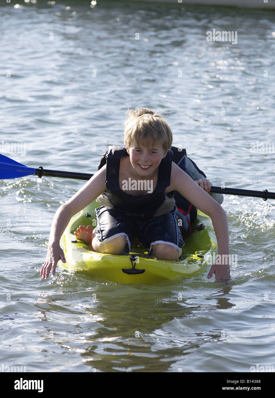 Deux jeunes garçons jouant dans la mer sur un kayak Banque D'Images