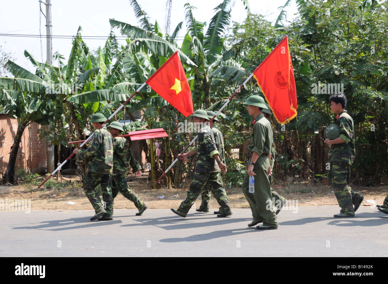 Armée vietnamienne portant des drapeaux marchant à travers Kon Tum Central Highlands Vietnam, Banque D'Images