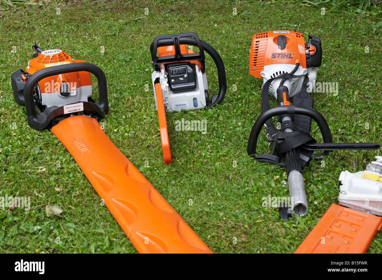 Les outils électriques Stihl alignés sur la pelouse avec gaines de protection sur les surfaces de coupe Stihl MS 180 KM MOTEUR Combi 90 Banque D'Images