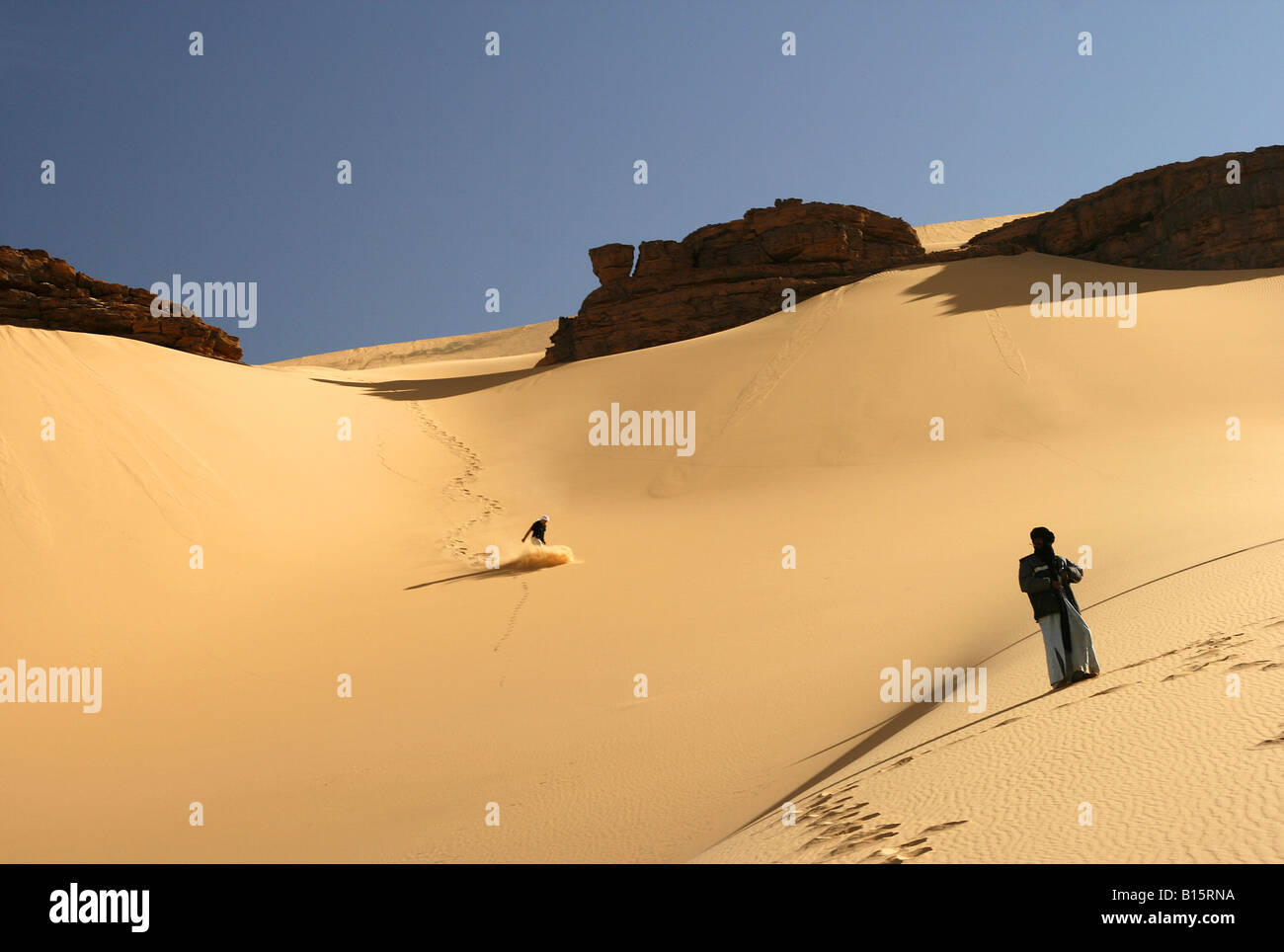 Touareg regarder glisser touristiques dans dune Oued Tin Tarabine Tassili Ahaggar Sahara Algérie Banque D'Images