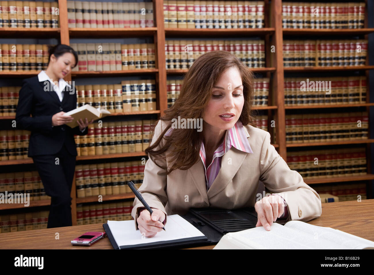 Hispanic woman reading library reference book Banque D'Images