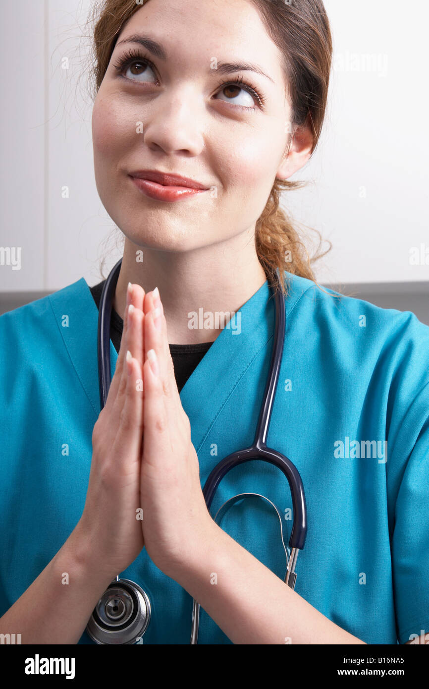 Hispanic female medical professional priant Banque D'Images