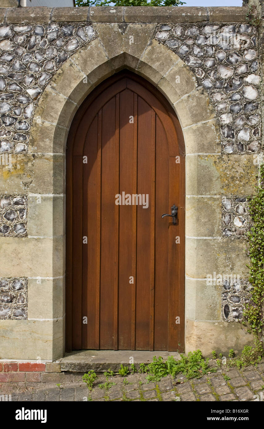 De style gothique en bois ensemble porte sur Sussex flint mur. UK Banque D'Images