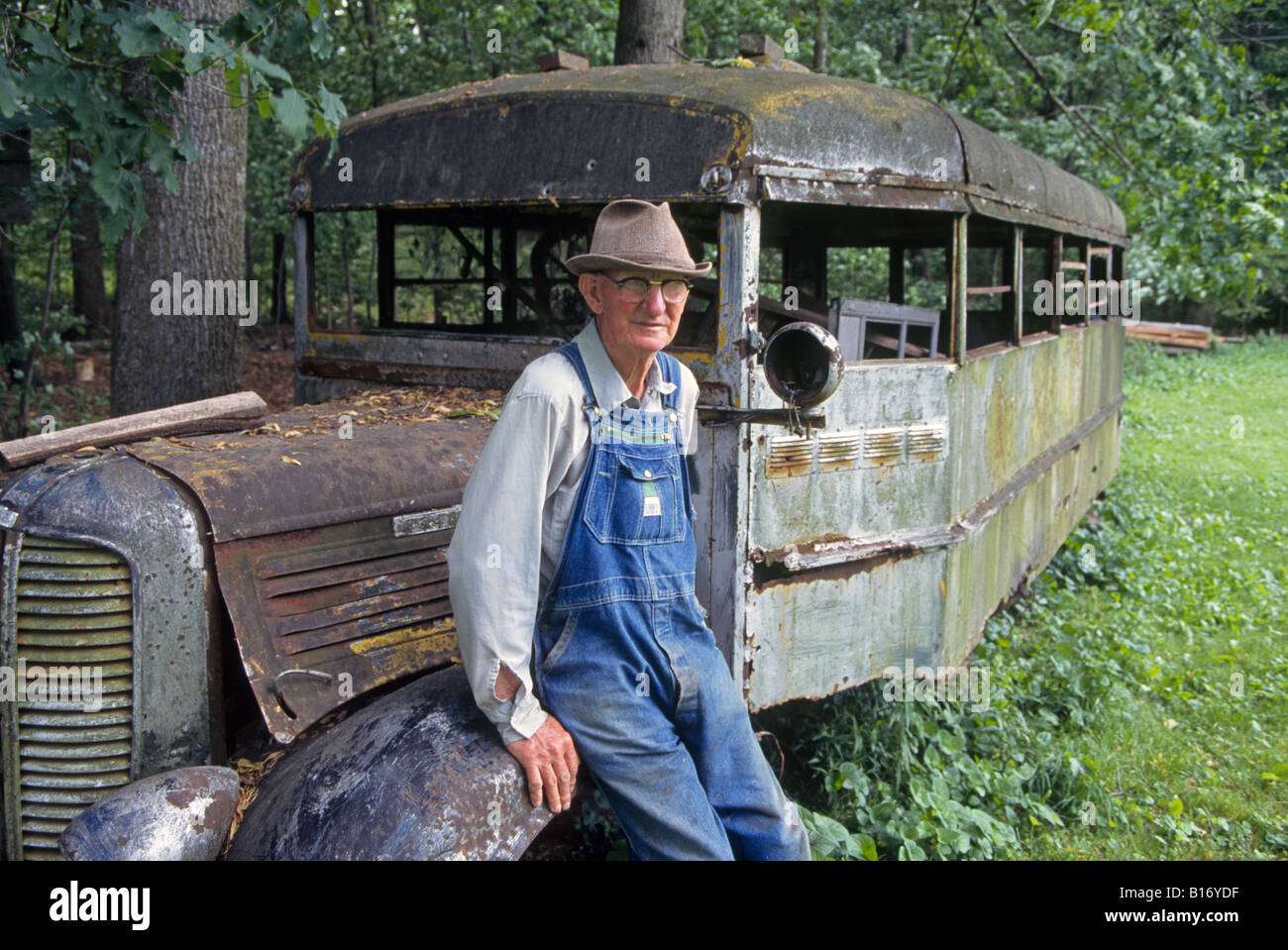 Un agriculteur âgé se distingue par ses anciens school bus sur sa petite ferme dans les montagnes de Shenandoah Banque D'Images