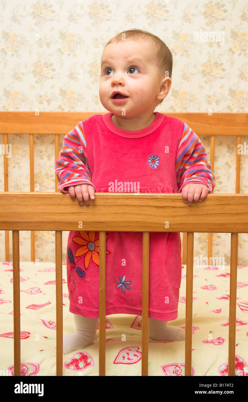 Un mignon un bébé de 9 mois debout dans son lit Photo Stock - Alamy