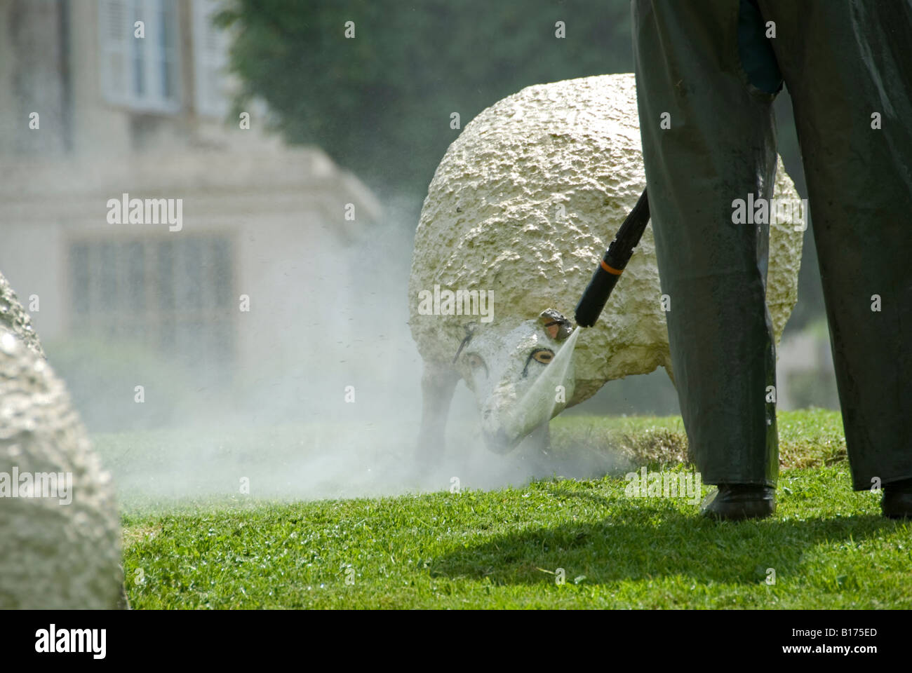 Stock photo d'un homme nettoyage du béton décoratif les moutons dans le village de Mézières sur Issoire Banque D'Images