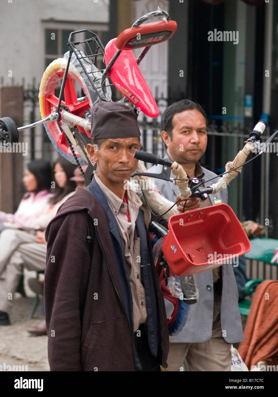 Nepali man carrying une bicyclette pour son enfant à Darjeeling Banque D'Images