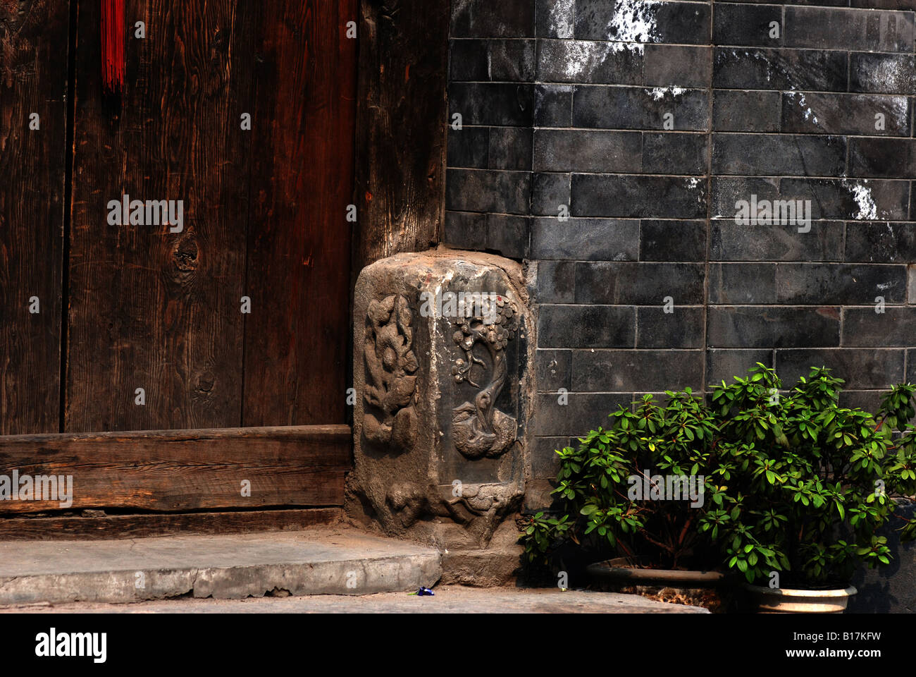 Plantes en pot en face d'une porte traditionnelle chinoise Banque D'Images