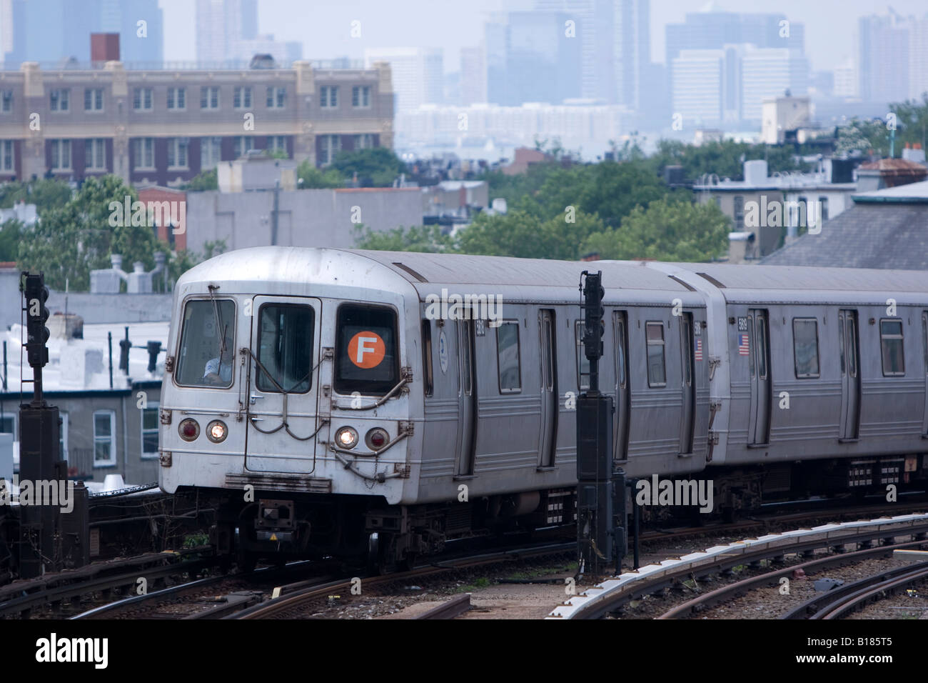 Un MTA New York City train monte vers Smith F / 9ème street station à Brooklyn, NY par une chaude journée de juin et brumeux. Banque D'Images