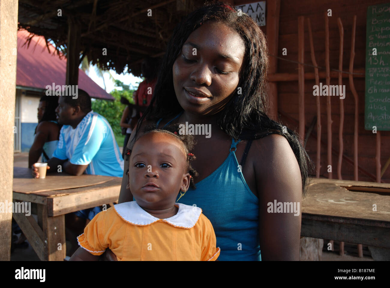 Jeune femme noire avec une petite fille sur ses genoux Banque D'Images