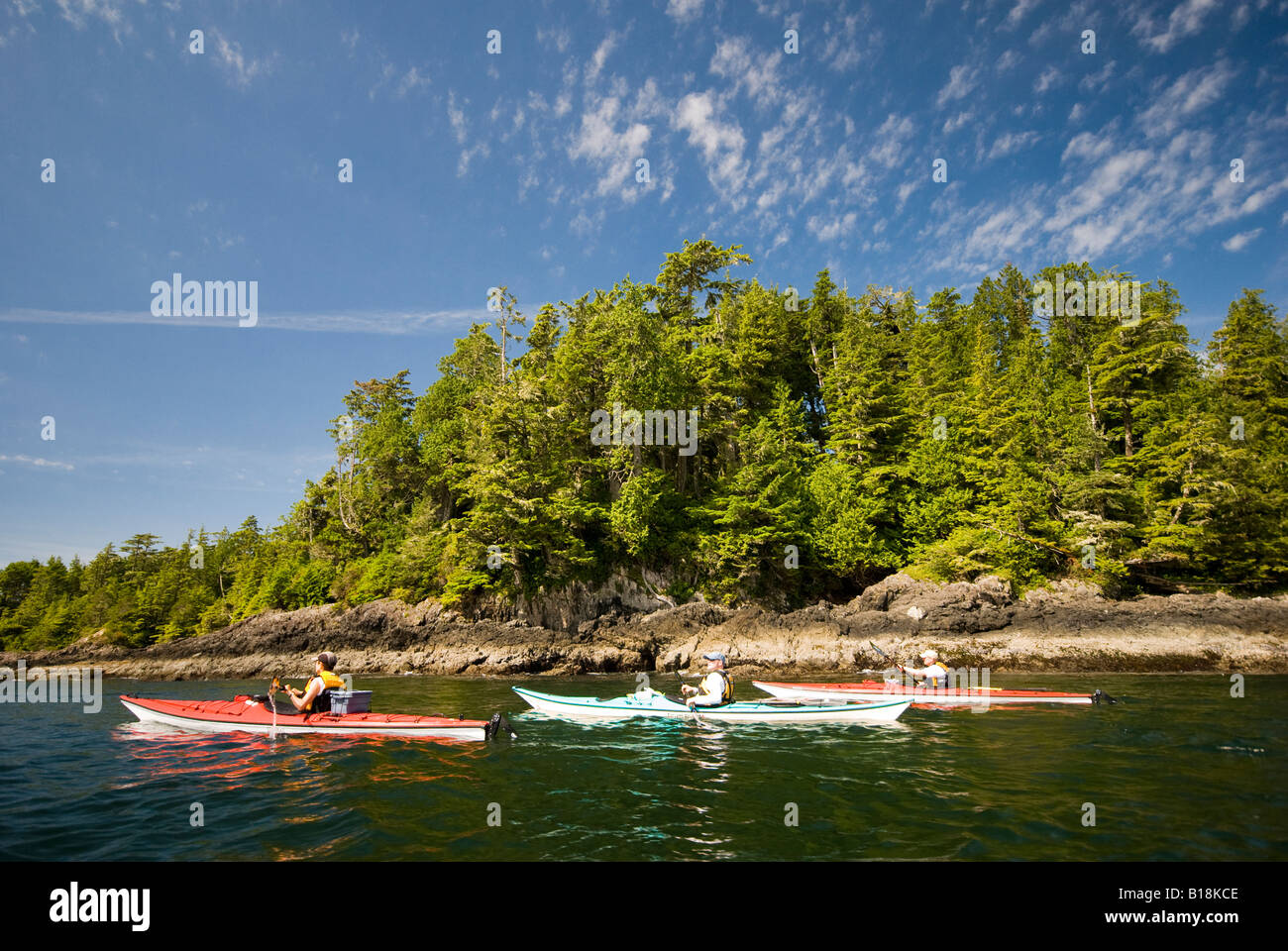 Les kayakistes de mer pagayer le long du rivage de l'île Vargas dans la baie Clayoquot près de Tofino, Colombie-Britannique, Canada. Banque D'Images