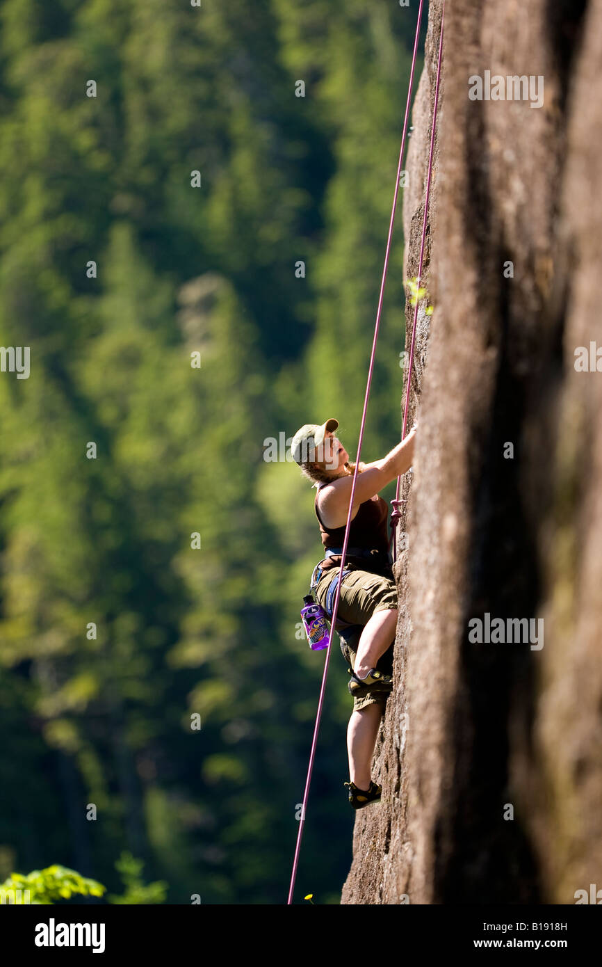 Female rock climber sur Terre Rouge (5,9) mur principal Crest Craigs dans le parc Strathcona. L'île de Vancouver, Colombie-Britannique, Canada Banque D'Images