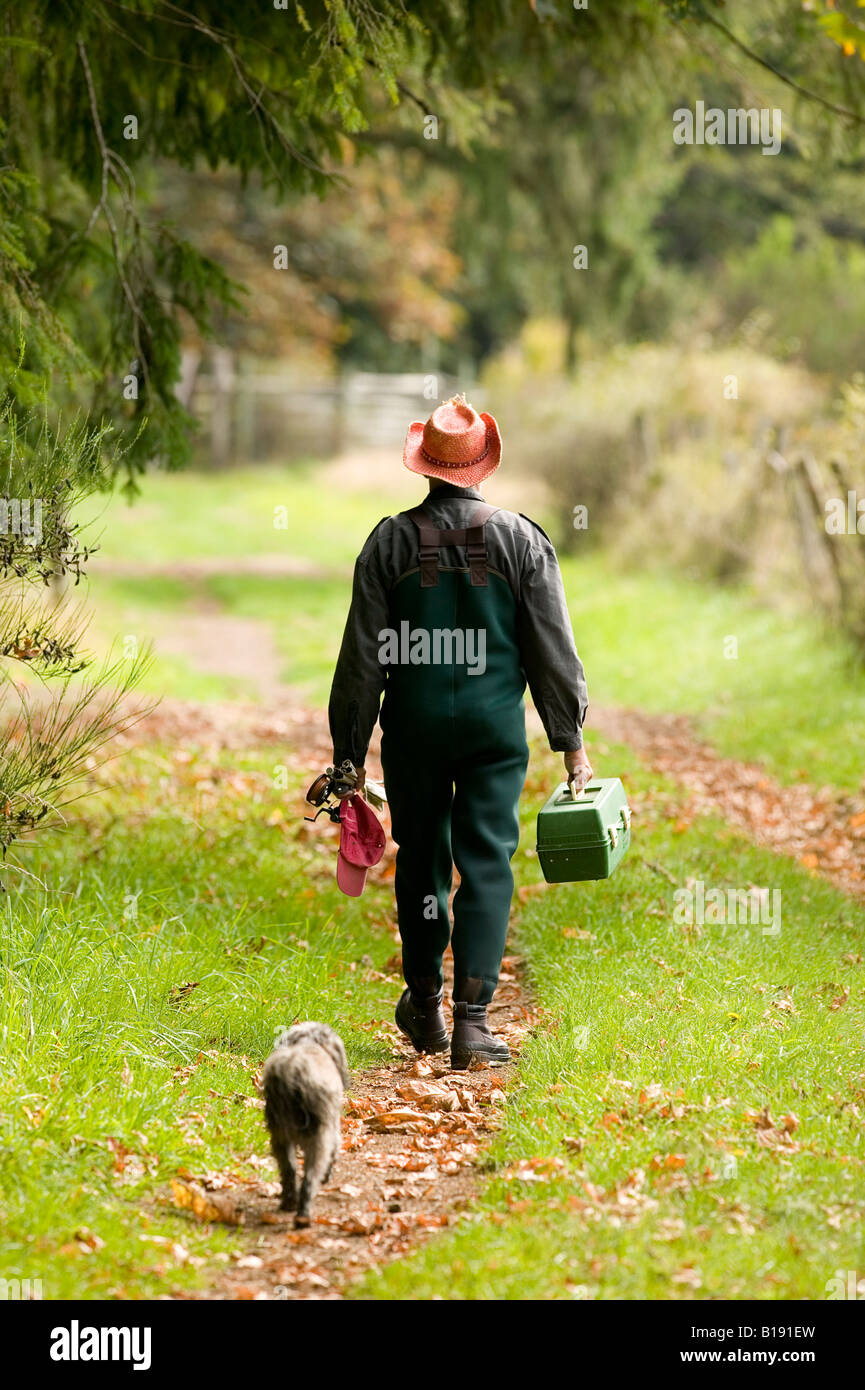 L'homme et le chien à la maison après une journée de pêche. Courtenay, l'île de Vancouver, Colombie-Britannique, Canada Banque D'Images