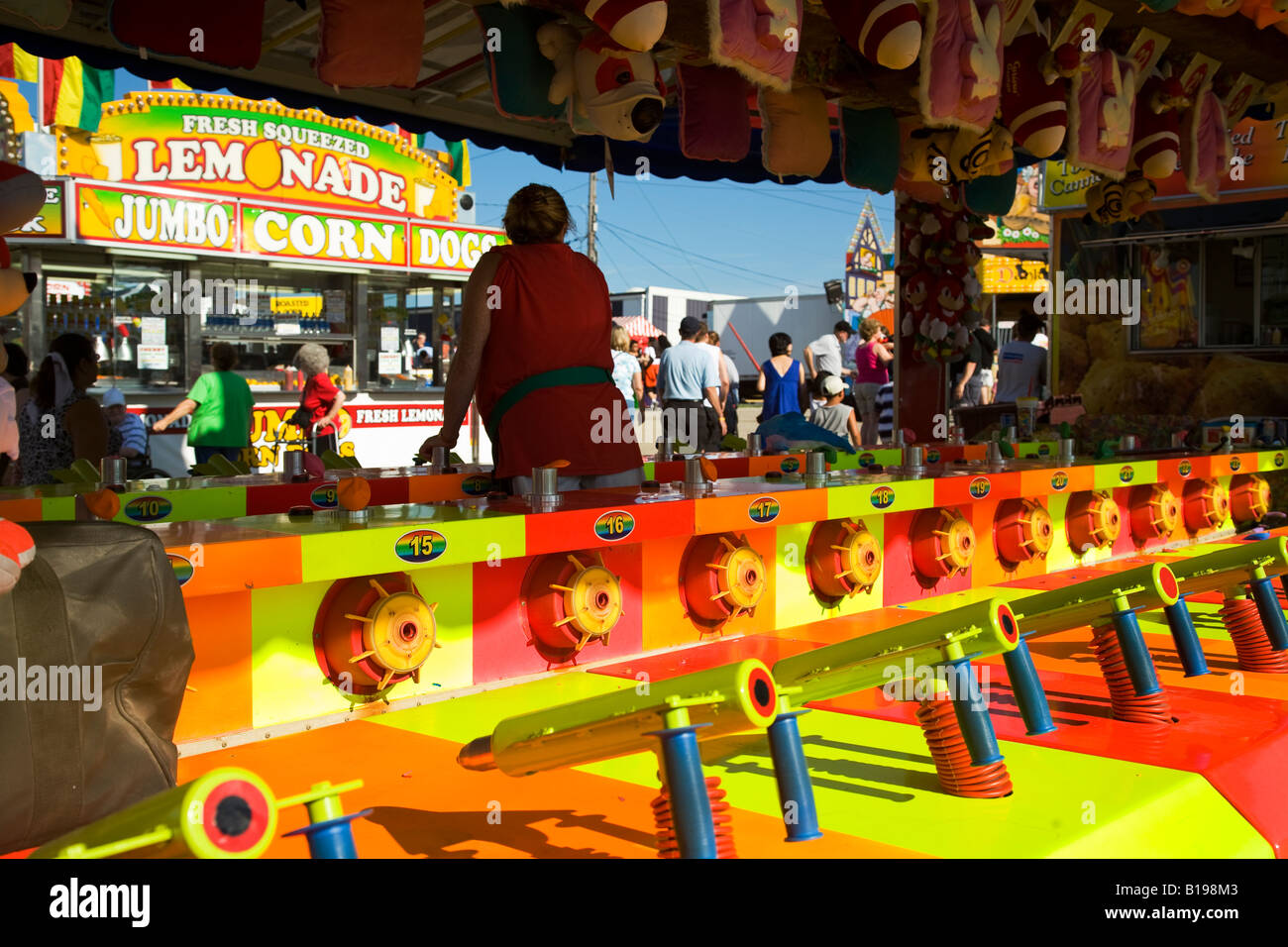 Grayslake ILLINOIS couleurs néon au tir au pistolet à eau jeu arcade galerie Lake County Fair stand stand opérateur carnaval femelle Banque D'Images