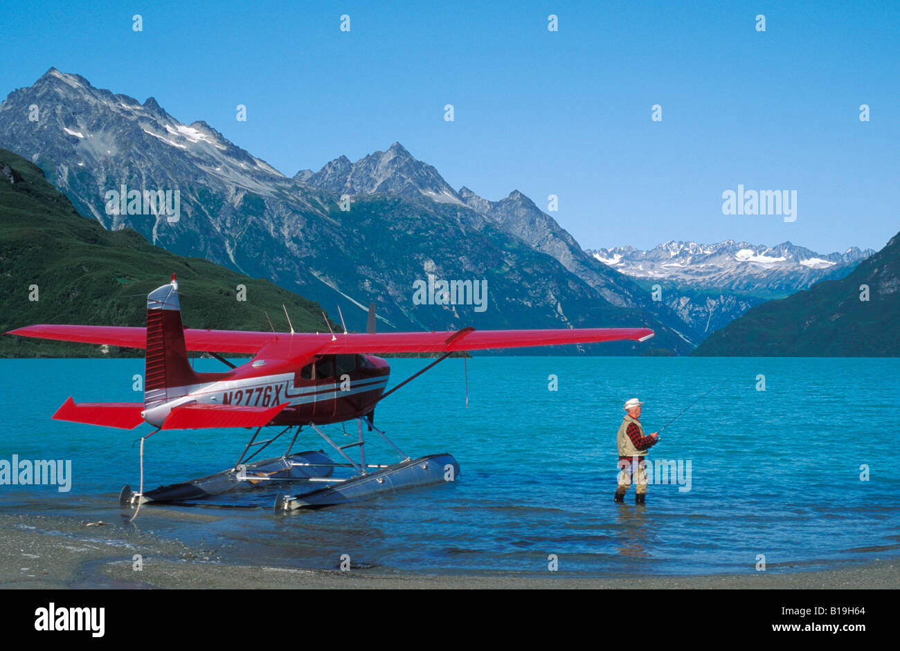 USA, Alaska, Lake Clark National Park. Yogi de pêche du saumon Kaufman à côté d'un avion Cessna 180 dans la région de Crescent Lake. Banque D'Images