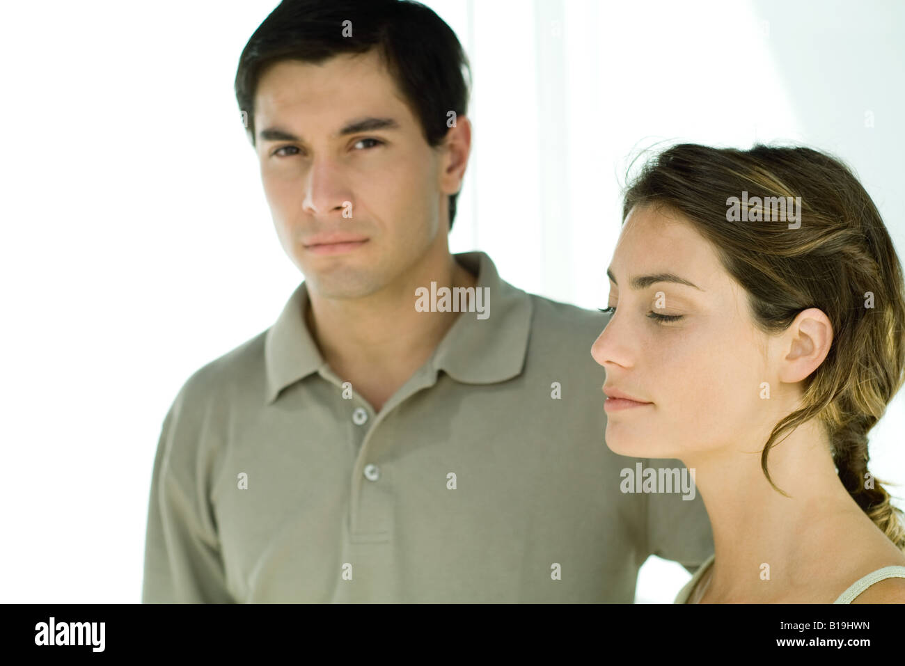 Jeune couple, man looking at camera, woman looking away Banque D'Images