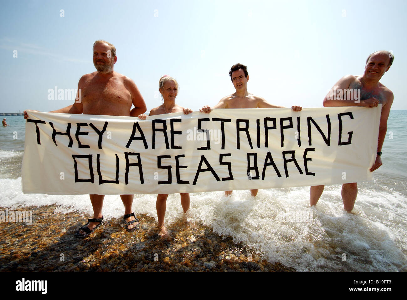 Nudistes tenir une pancarte avec les mots qu'ils sont dénudés nos mers nu à protester contre les atteintes à l'environnement pour le climat. Banque D'Images