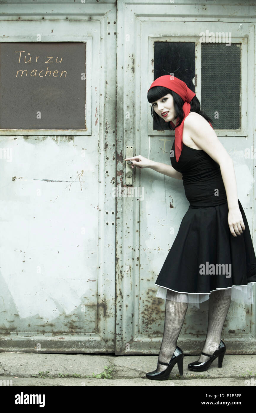 Jeune femme debout devant une porte, smiling, portrait Photo Stock - Alamy